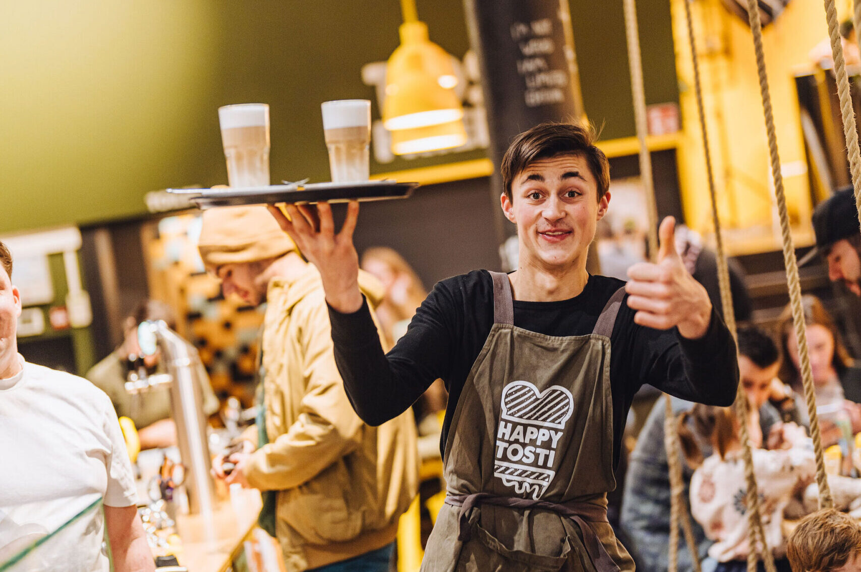 Julian (21) werkt via Social Capital bij Happy Tosti in Den Haag. Foto: Social Capital